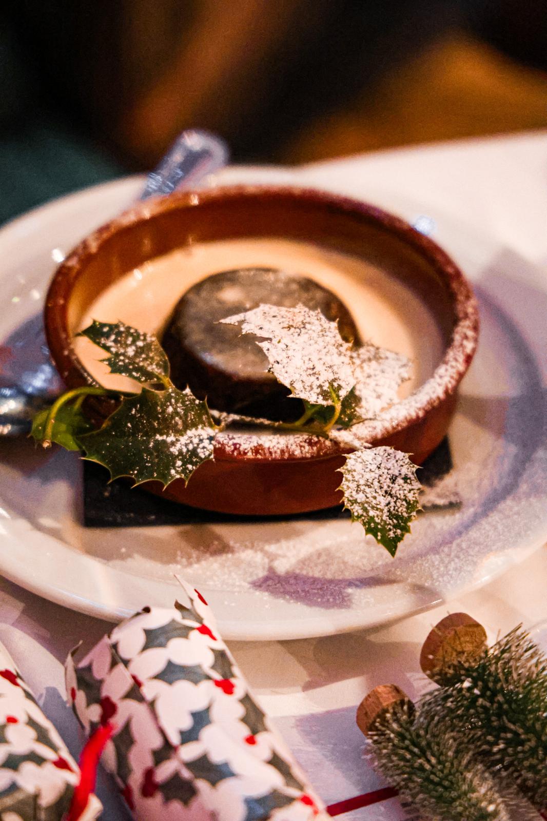 Christmas pudding topped with holly and dusted with icing sugar